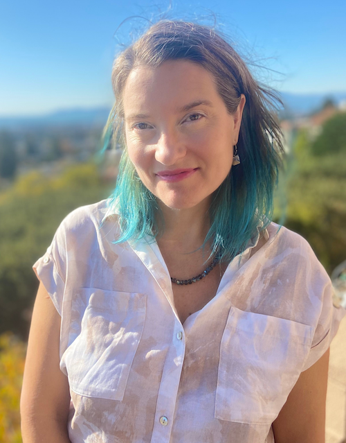 woman with desert background in white shirt with blue hair