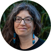 Woman with long hair, wearing glasses and smiling