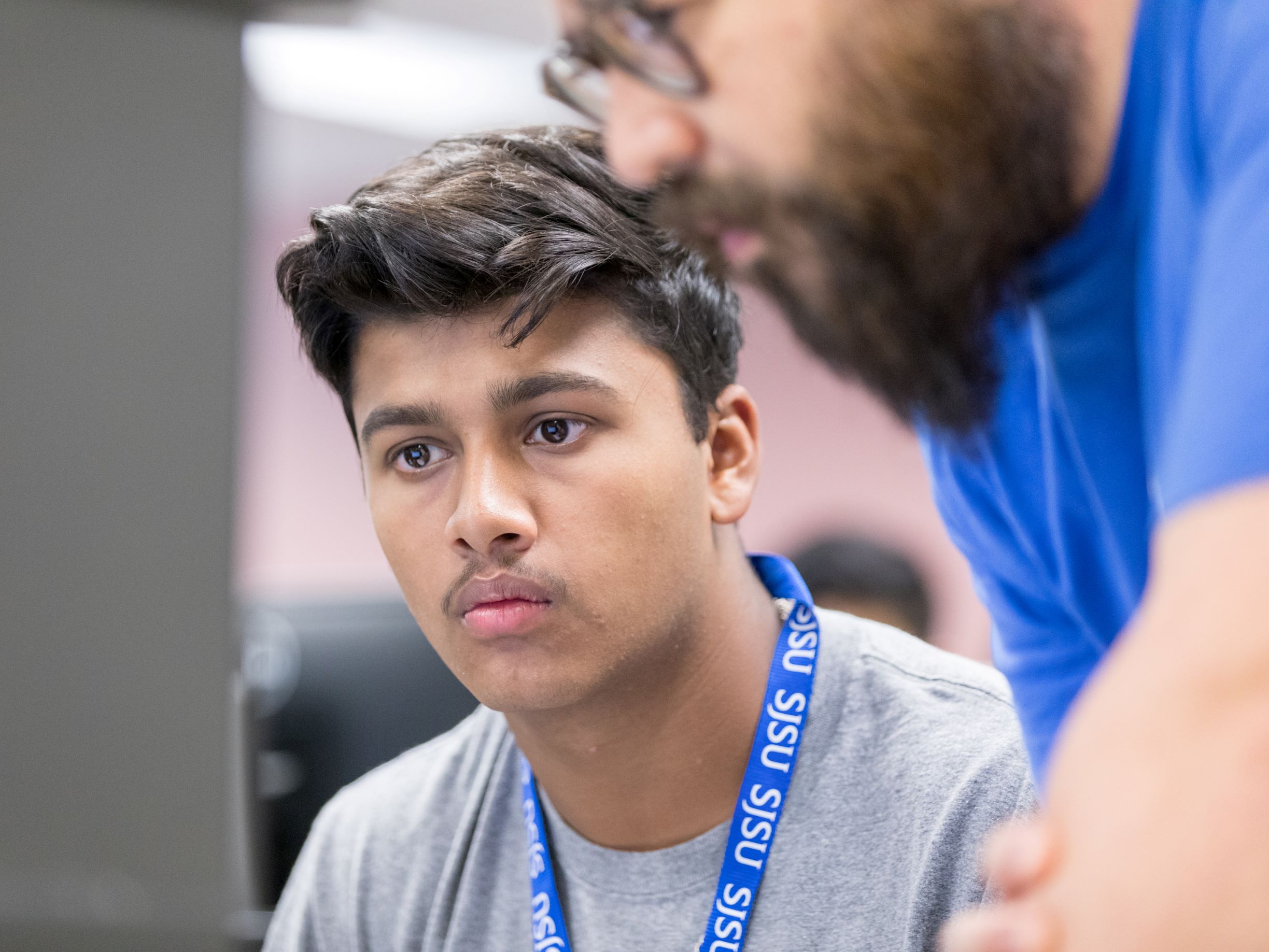 SJSU staff assists a student focused on their 